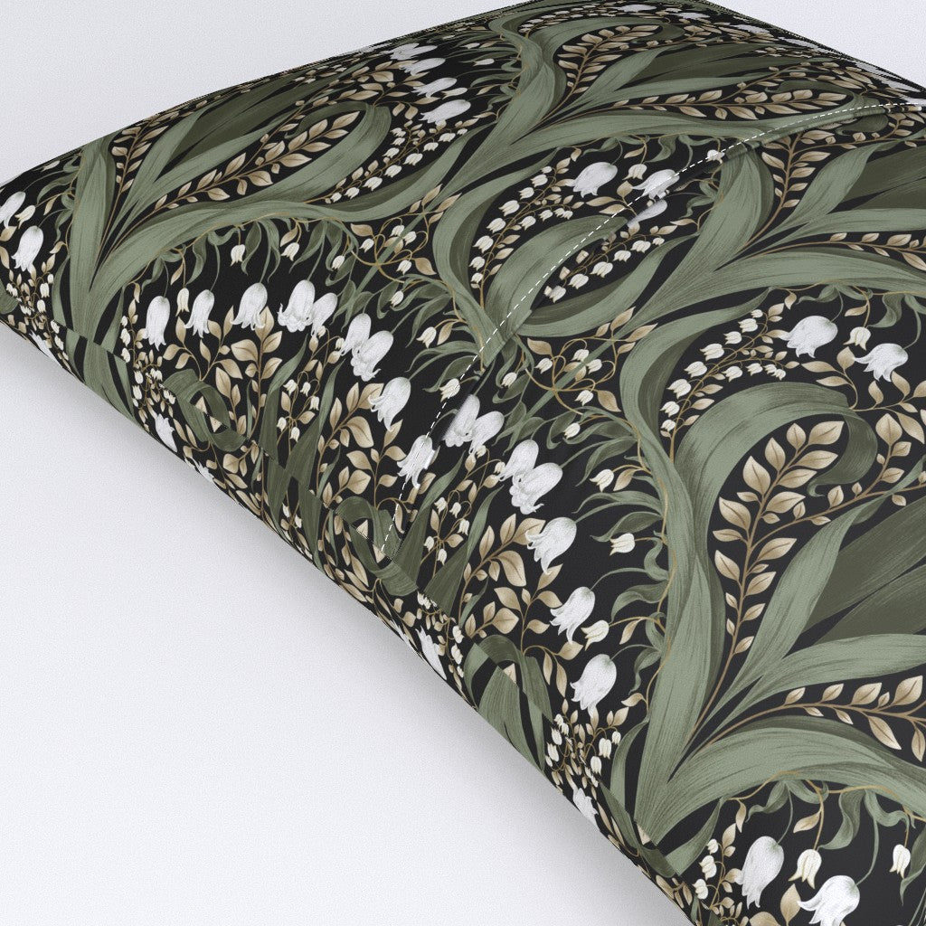 Rectangular pillow featuring a black Art Nouveau botanical pattern with green leaves and white lily‑of‑the‑valley flowers.