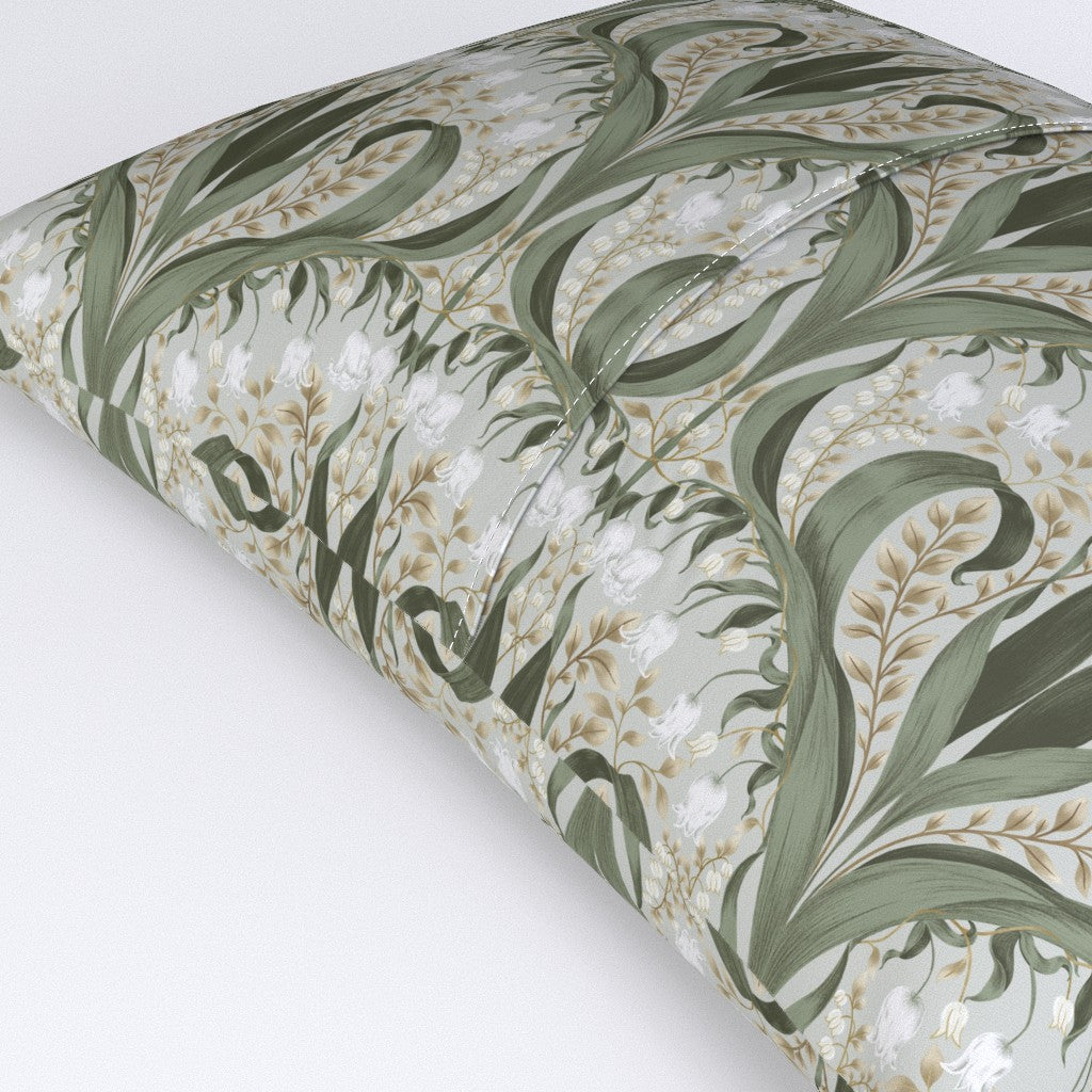 Decorative pillow featuring an Art Nouveau botanical pattern with green leaves and white flowers on a light background.