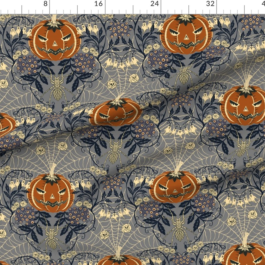 Halloween-themed fabric with pumpkins and spider webs on a blue background