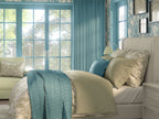 Heritage‑style bedroom with duck‑egg blue and cream décor, featuring floral wallpaper, matching blue curtains, patterned pillows, and a classic upholstered chair. Soft, elegant interior ideal for traditional home décor and heritage revival inspiration.
